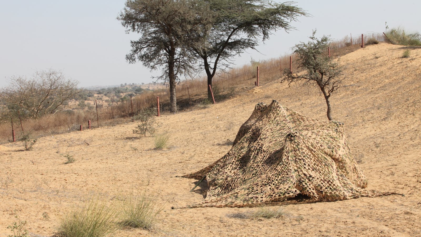 CAMPRO multi-spectral camouflage net deployed in the field, material and garnish condition visible up close